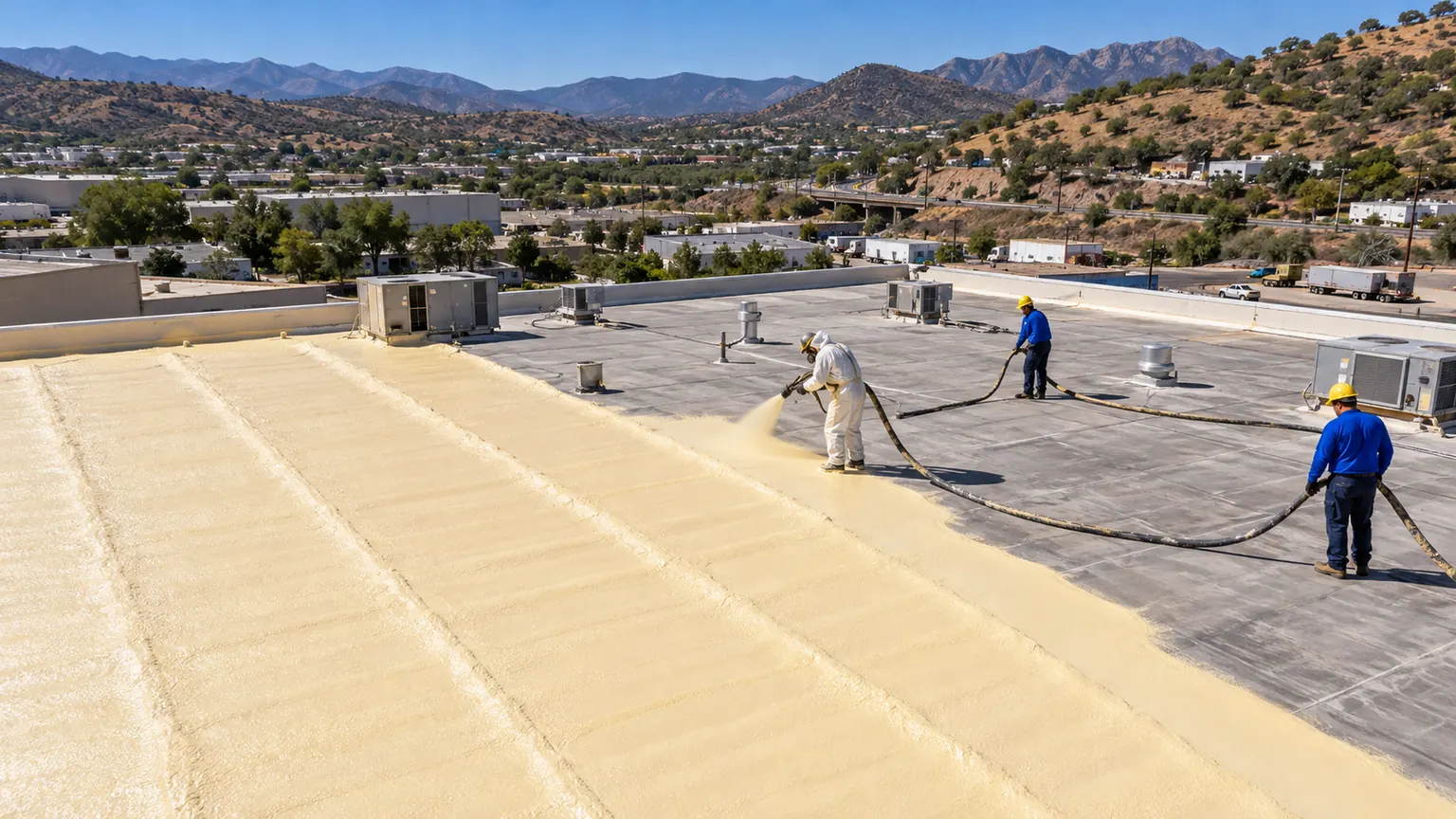 Drone view of a flat roof being foamed in lanes beside the old roof surface